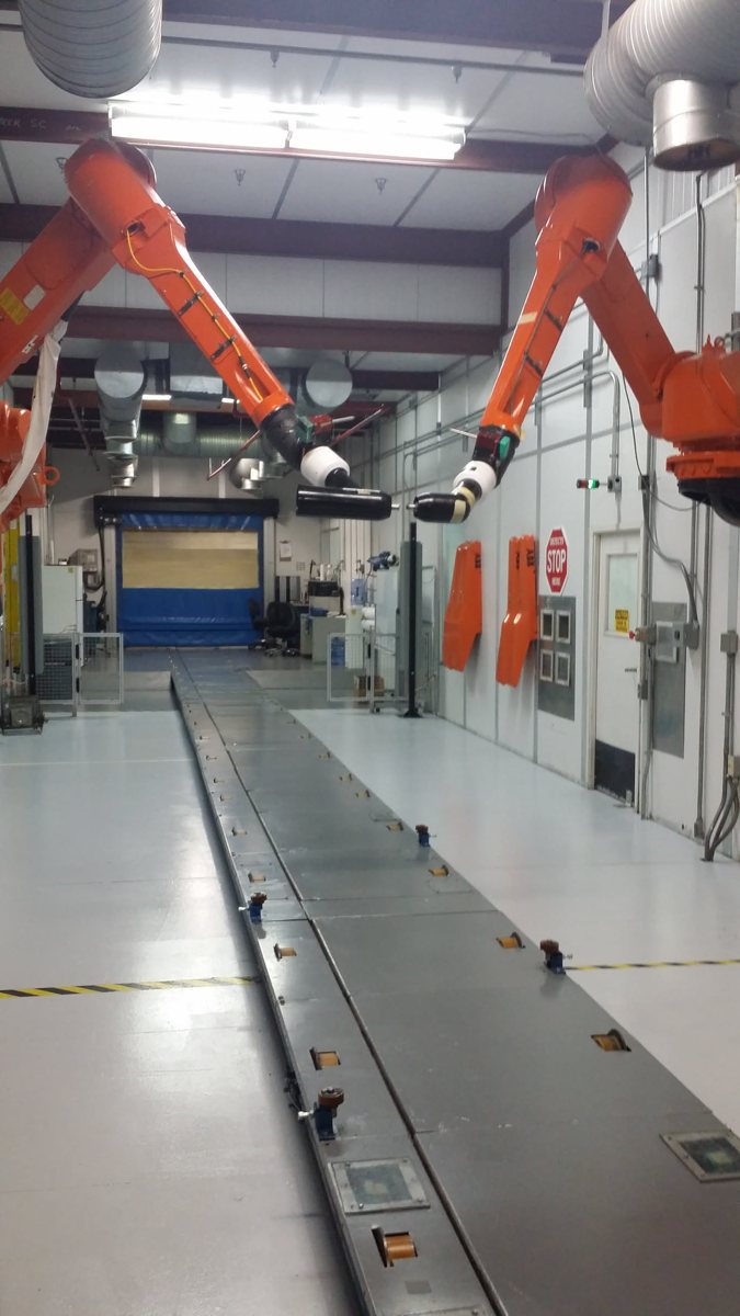 Orange paint robots on both sides of an empty paint booth